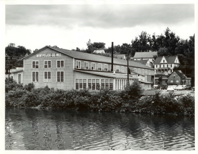 Old photo of large building along a river