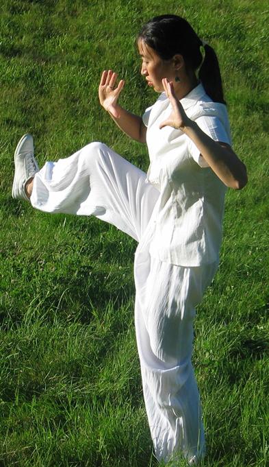 A women practices Tai Chi in a yard